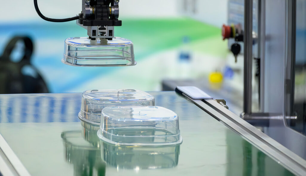 High-precision robotic automation using vacuum EOAT to handle and position delicate injection molded plastic components on the conveyor.